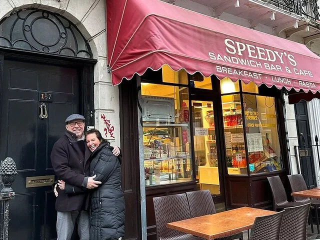 Un couple souriant posant ensemble devant le Speedy's Sandwich Bar & Cafe.