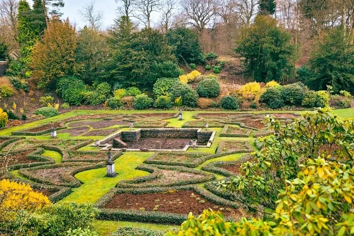 Un jardin à la française au design complexe avec des haies basses formant des motifs géométriques.