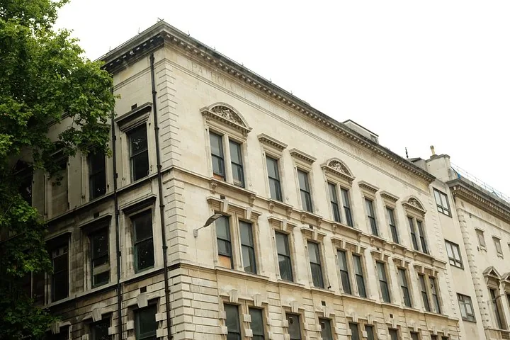 Die Außenfassade eines mehrstöckigen Steingebäudes mit klassischer Architektur.