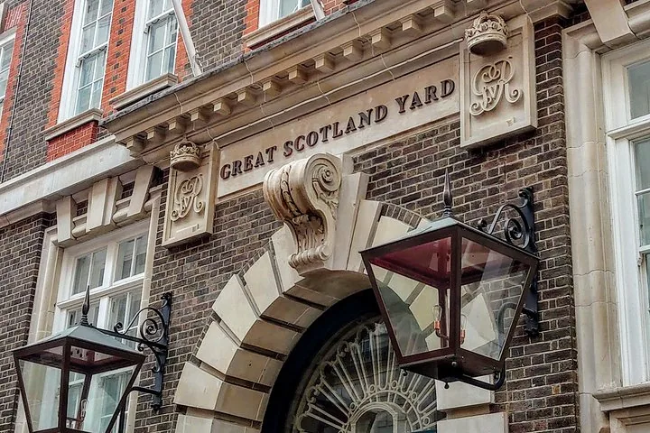 Una entrada ornamentada que dice "GREAT SCOTLAND YARD" con un farol colgante.